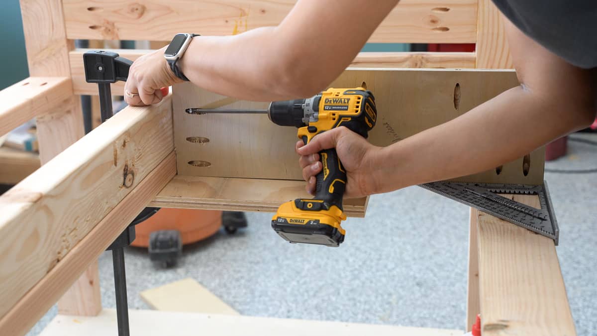 Woman attaching dividers to the workbench for supporting the drawers