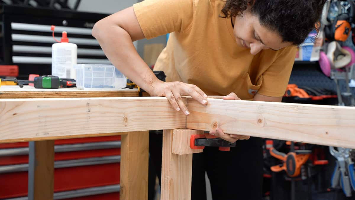 Woman attaching aprons to the sides of the workbench