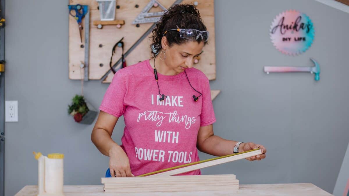 Anika measuring wood for a project
