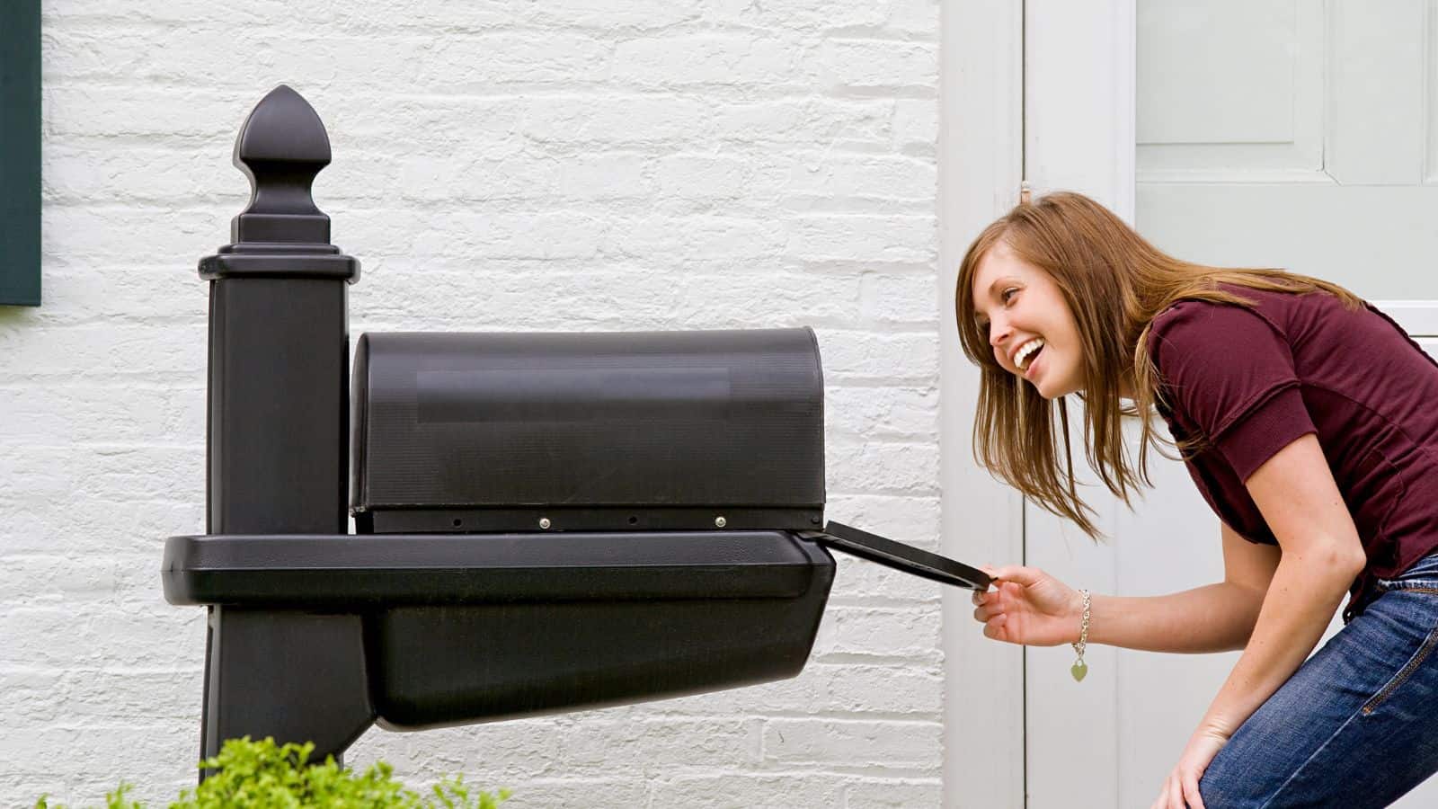 woman looking inside new mailbox