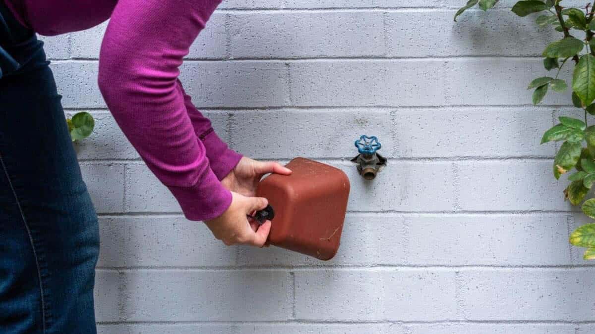 woman attaching a spigot cover outside