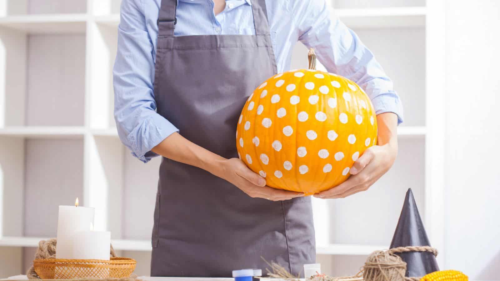 woman holding a painted pumpkin