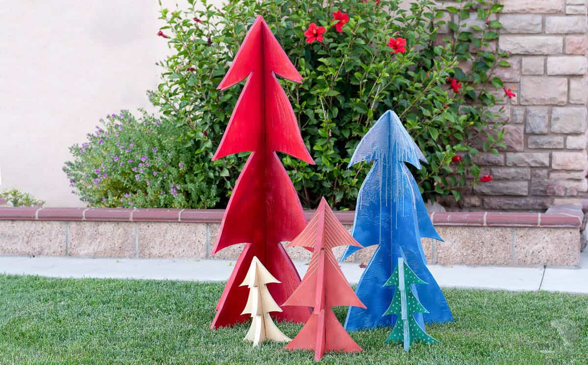 Four plywood Christmas trees painted red, blue and green