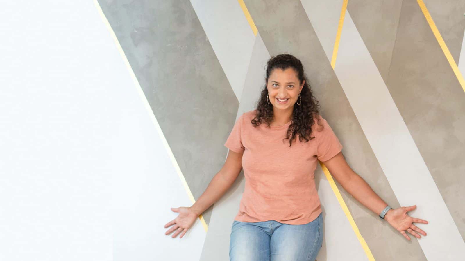 Anika standing in front of cement accent wall