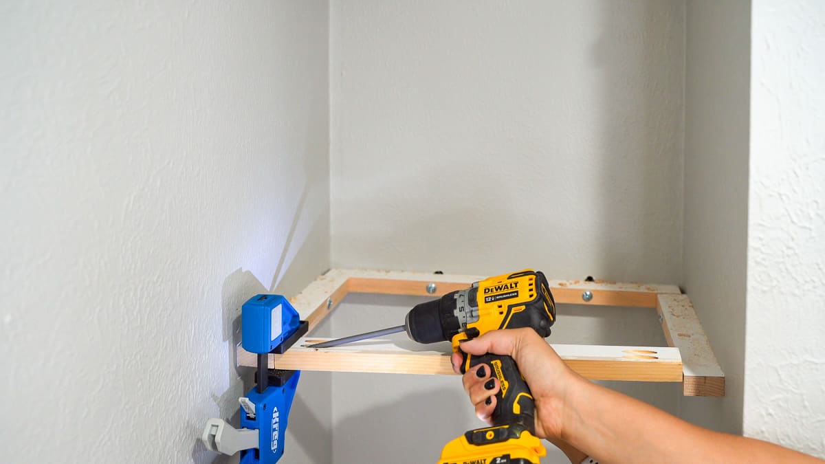 Woman attaching a board to the side brackets using pocket hole screws