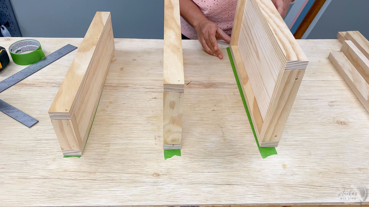Aligning the shelves to the masking tape on the workbench