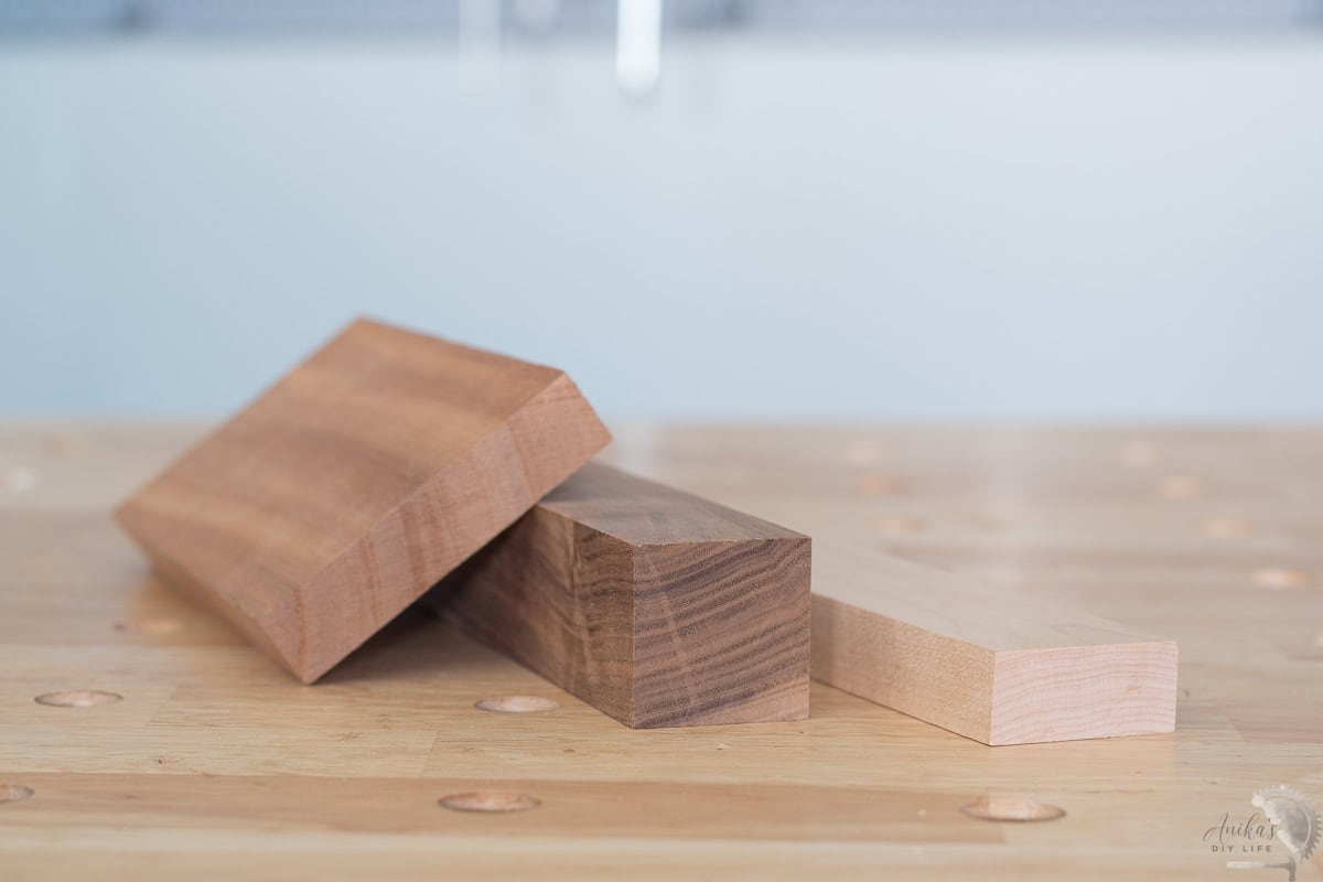 mahogany, walnut and maple boards on a workbench in a workshop.