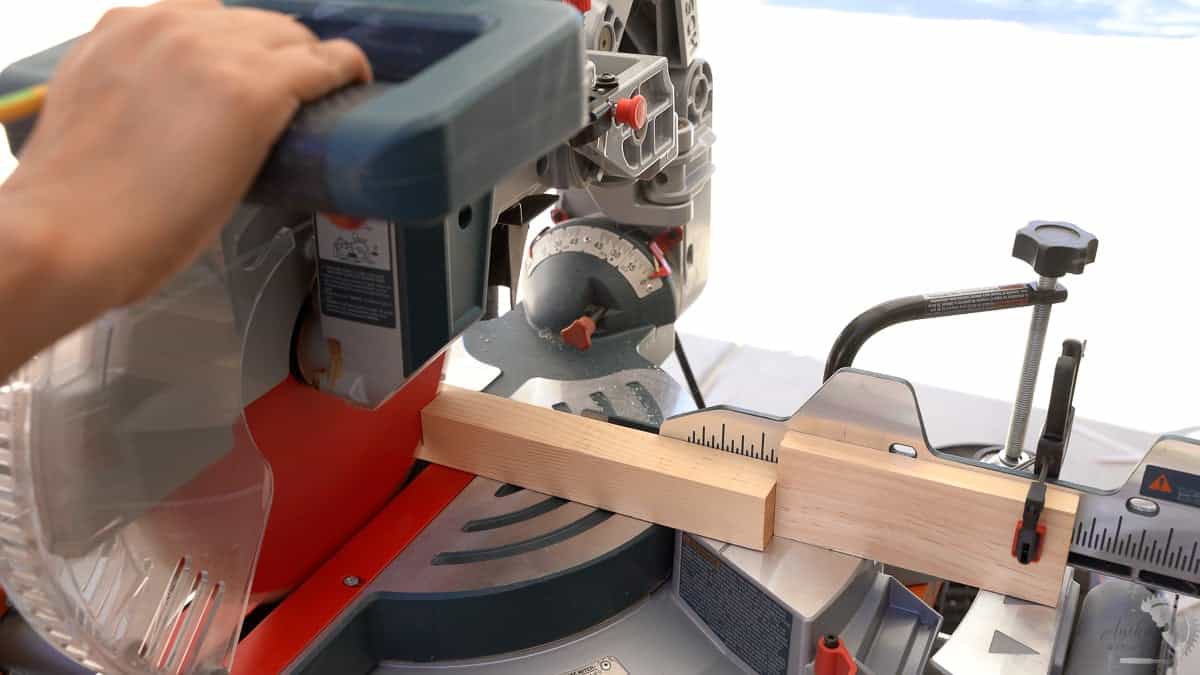 Cutting a board on the miter saw with a stop block clamped on the fence
