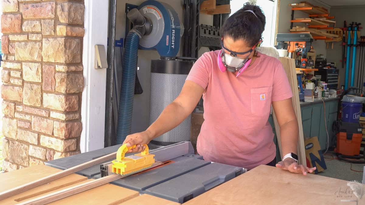 Woman ripping the plywood strips on a table saw