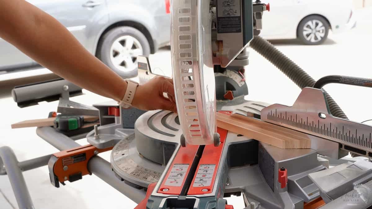 cutting the plywood board on the miter saw at 45 degrees