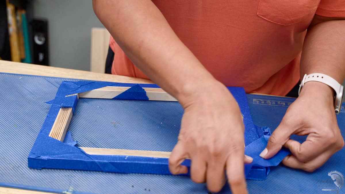 Adding tape to the edges for the glue up for the plywood picture frame