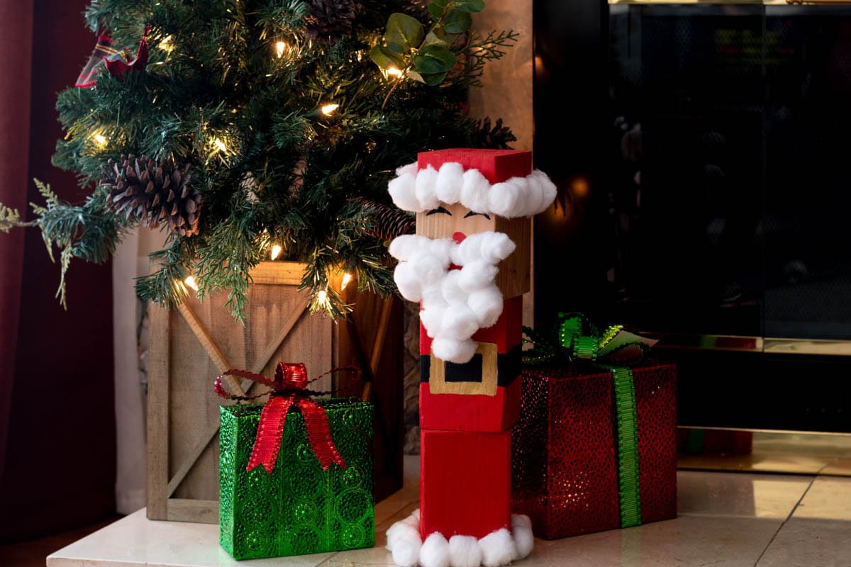 DIY wood block Santa next to presents and Christmas tree