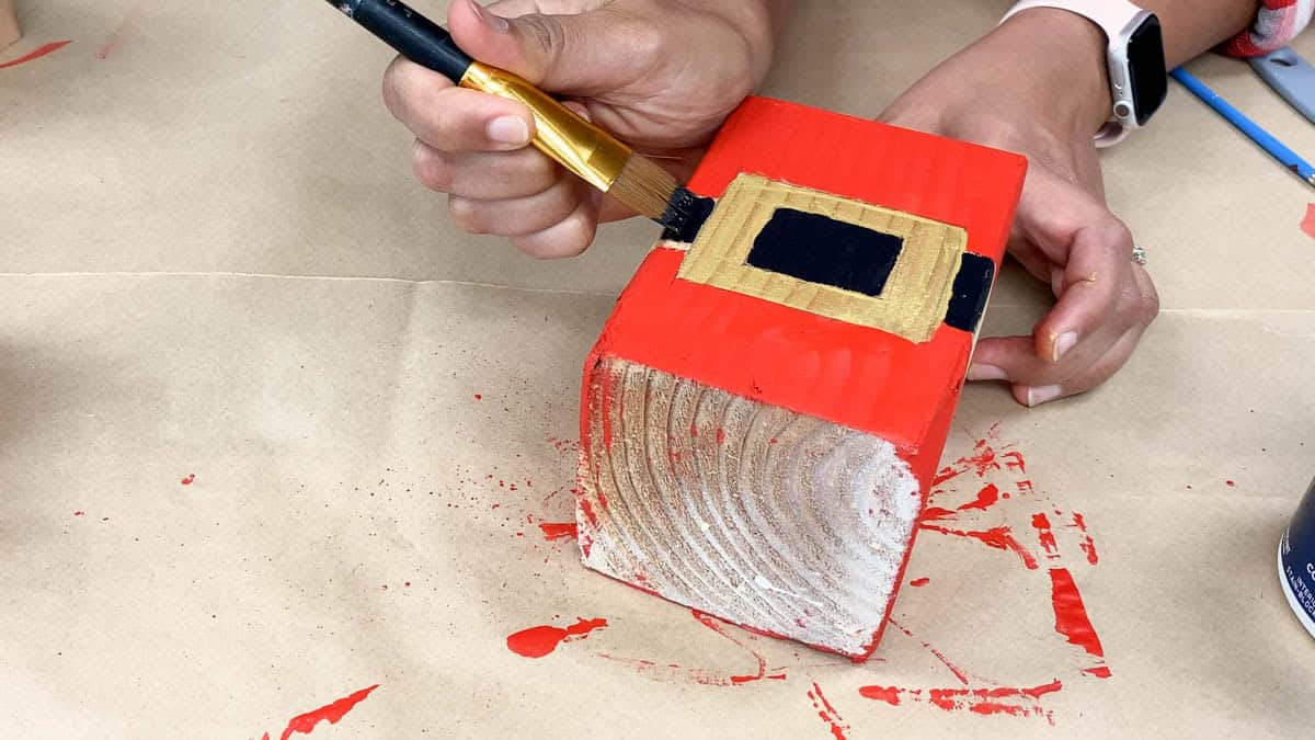 Painting Santa's belt and buckle on the middle block