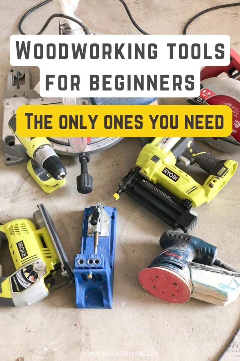 Flat lay collection of woodworking tools for beginners on a workshop floor, including a Ryobi drill, brad nailer, and jigsaw, a blue Kreg pocket hole jig, a Bosch orbital sander, and a miter saw. Text overlay reads: "Woodworking Tools for Beginners: The Only Ones You Need."