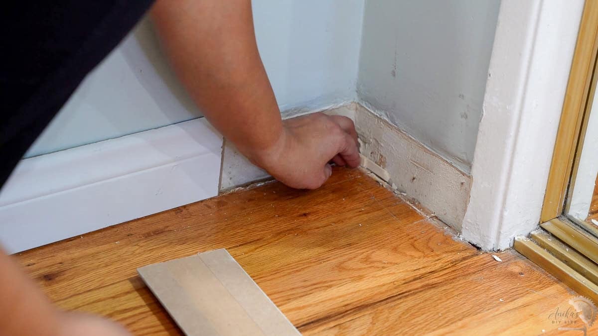 using popsicle sticks behind the basebaord to fix the gap behind the basebaord.