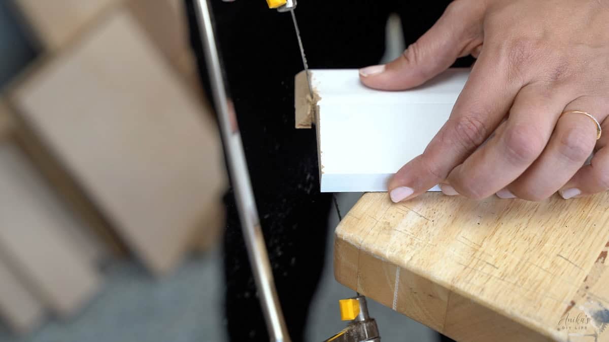 Cutting the baseboard with a coping saw.