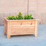 Learn how to build a DIY cedar raised planter for under $30 with these step-by-step tutorials and free plans. Perfect for herbs and vegetables.