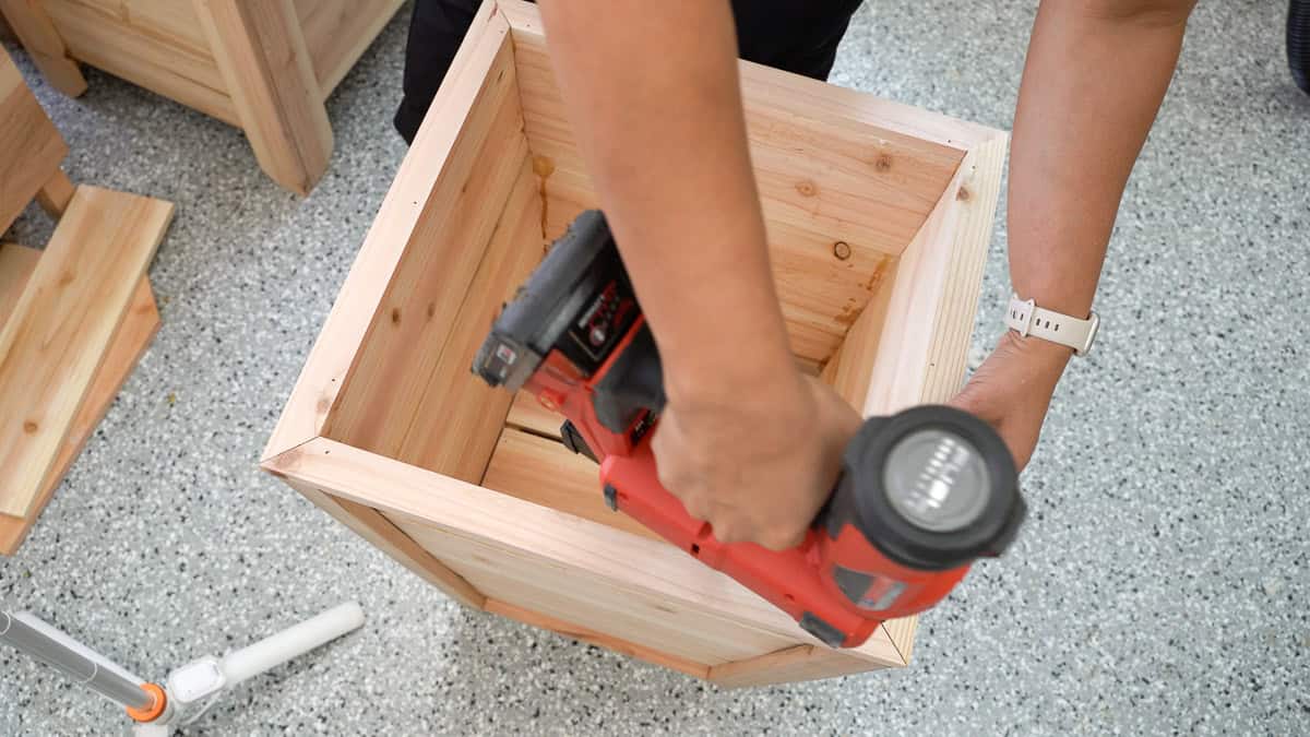 Attaching the top trim to the planter with a nail gun