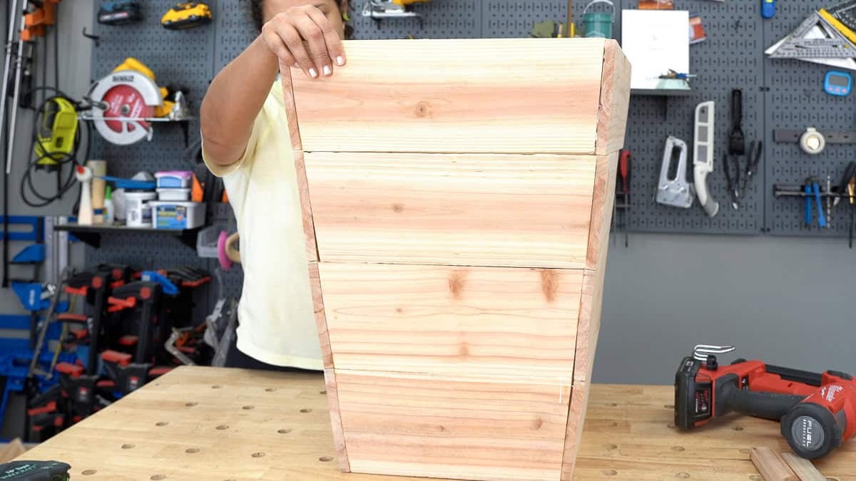 Anika stacking up the boxes on top of each other on a workbench
