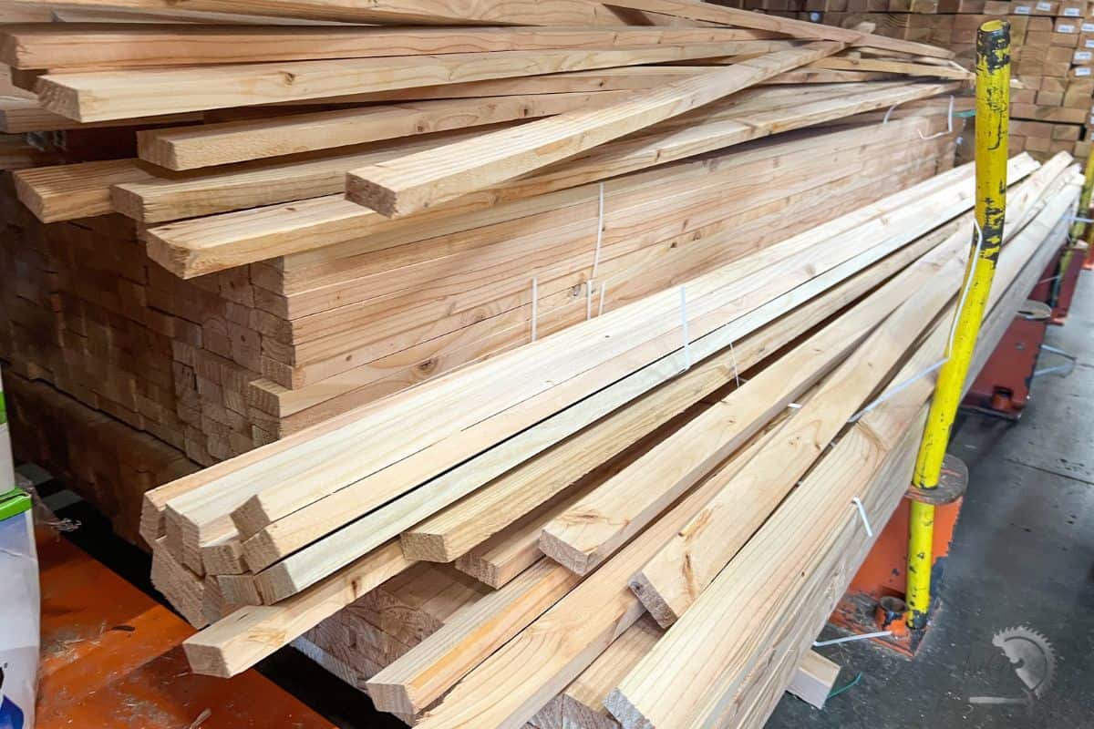 Wooden planks stacked for woodworking or DIY furniture project at Anika's DIY Life.