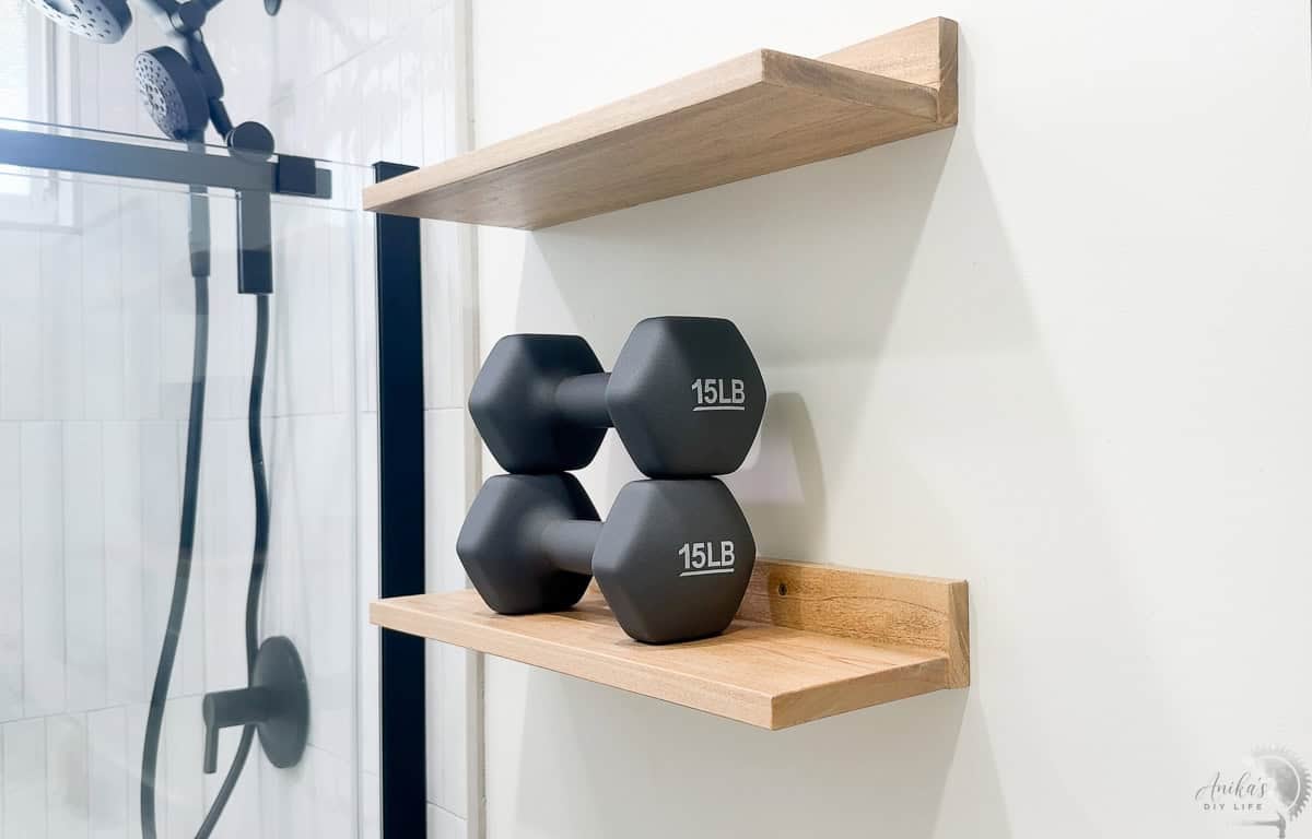 Easy thin DIY floating Shelves in hung on the bathroom wall with 30 Lb dumbells on it.