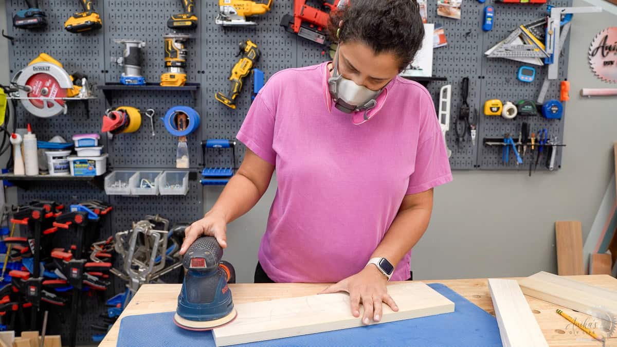 Anika Sanding the boards for the DIY floating shelf
