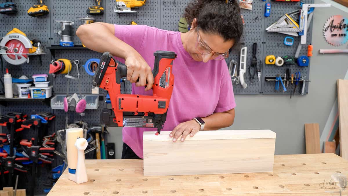 Anika Adding brad nails to hold the boards in place to build the easy diy floating shelf
