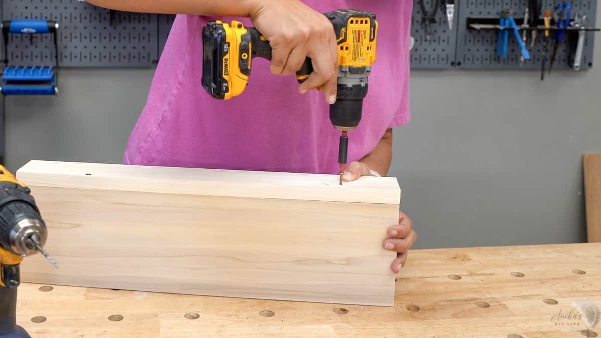Driving a countersunk screw into the edge of the floating shelf project