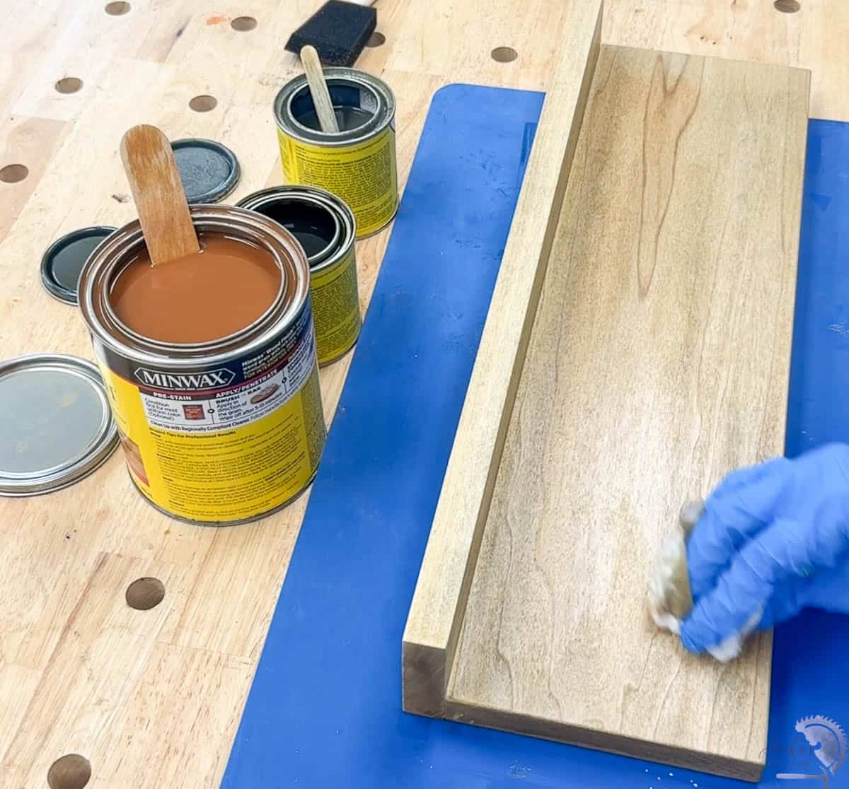 Applying stain. to the floating shelf
