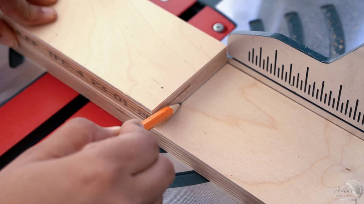using a board to mark the length for the next board with a pencil.
