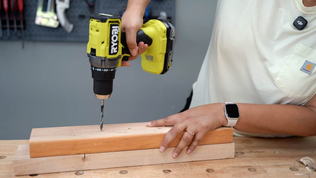 using a ryobi drill to make a hole in a 2x4