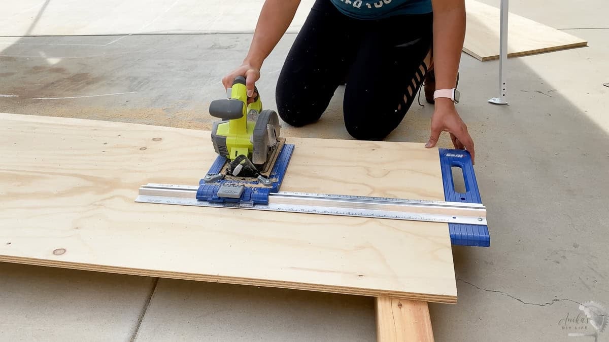 Anika cutting plywood with a circular saw and a rip cut guide