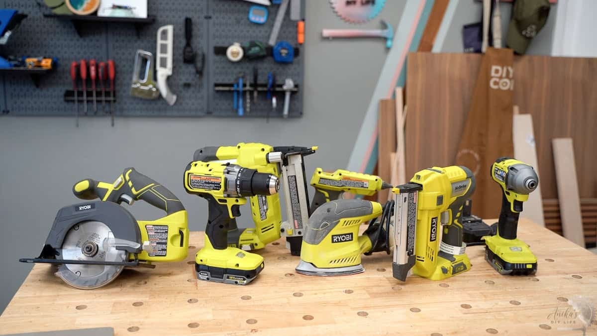 A collection of ryobi tools for beginners on a workbench in a woodworking workshop